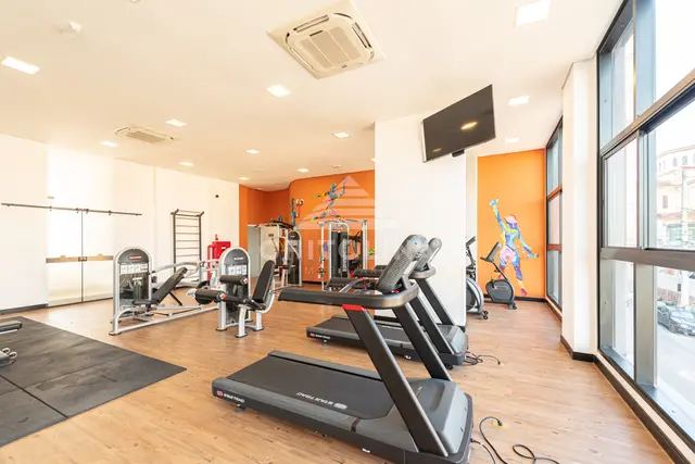 Esteiras e aparelhos de cardio na academia do Edifício Cathedral, com ar-condicionado, TV e espelho.