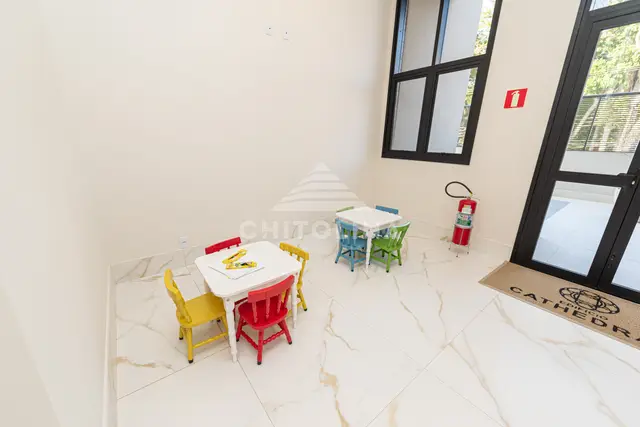 Espaço kids do Edifício Cathedral com mesinhas e cadeiras infantis coloridas.