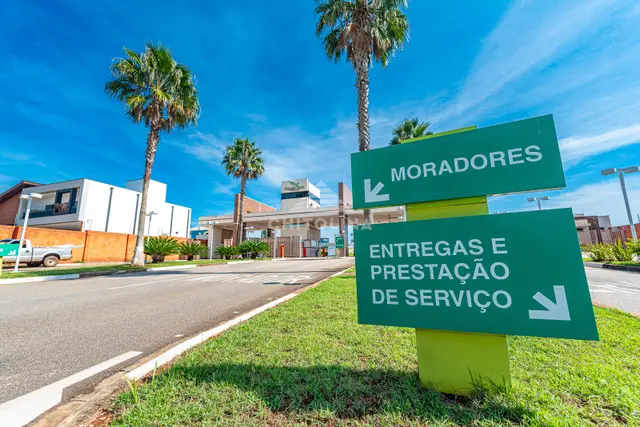 Placas verdes na entrada do Residencial Golden Ville indicando as faixas de moradores e de entregas e serviços.