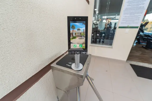 Catraca de aço inox com leitor facial na entrada da academia.